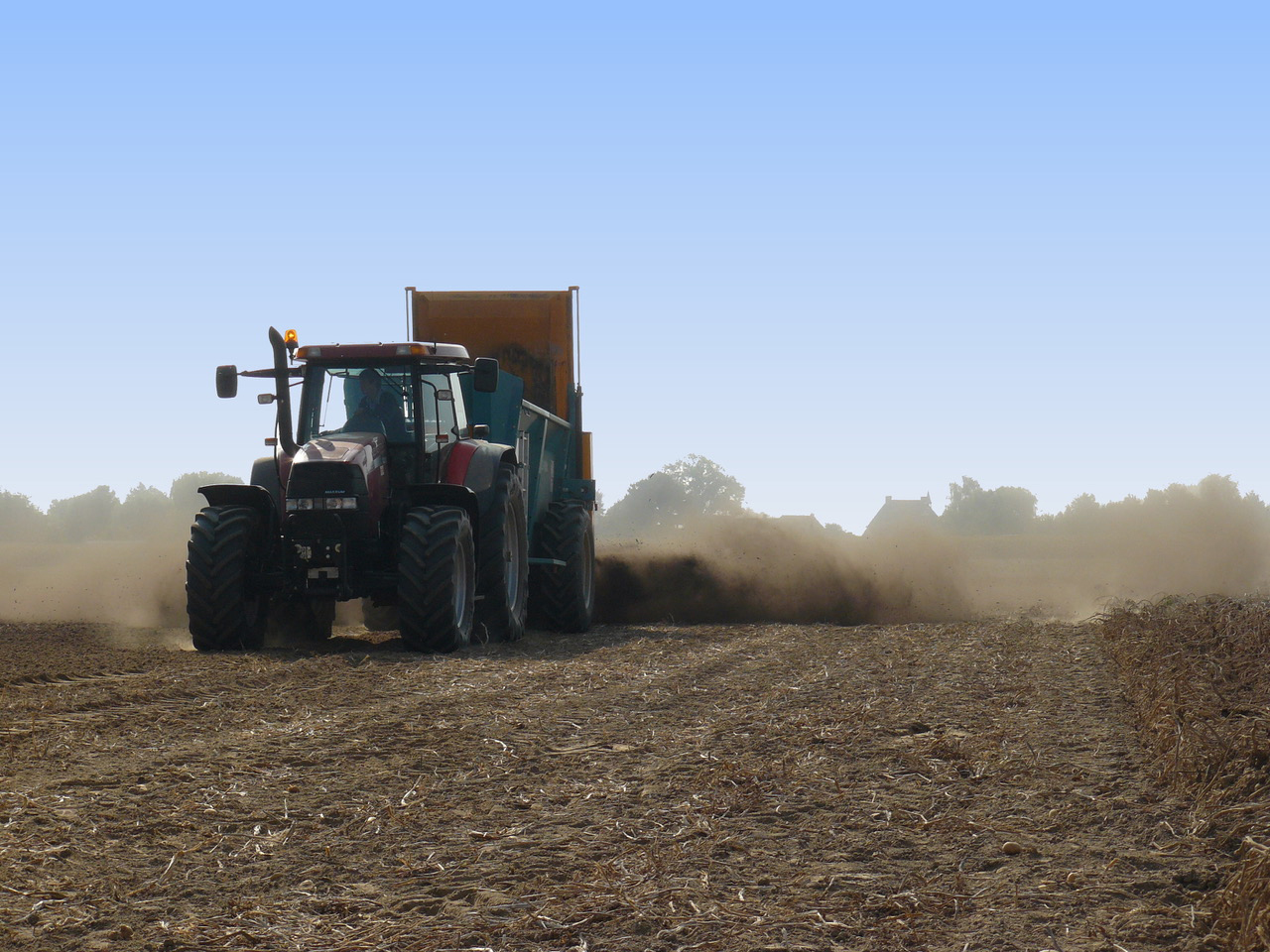 Foto: (stuivende) droge compost uitrijden met trekker en kiepwagen